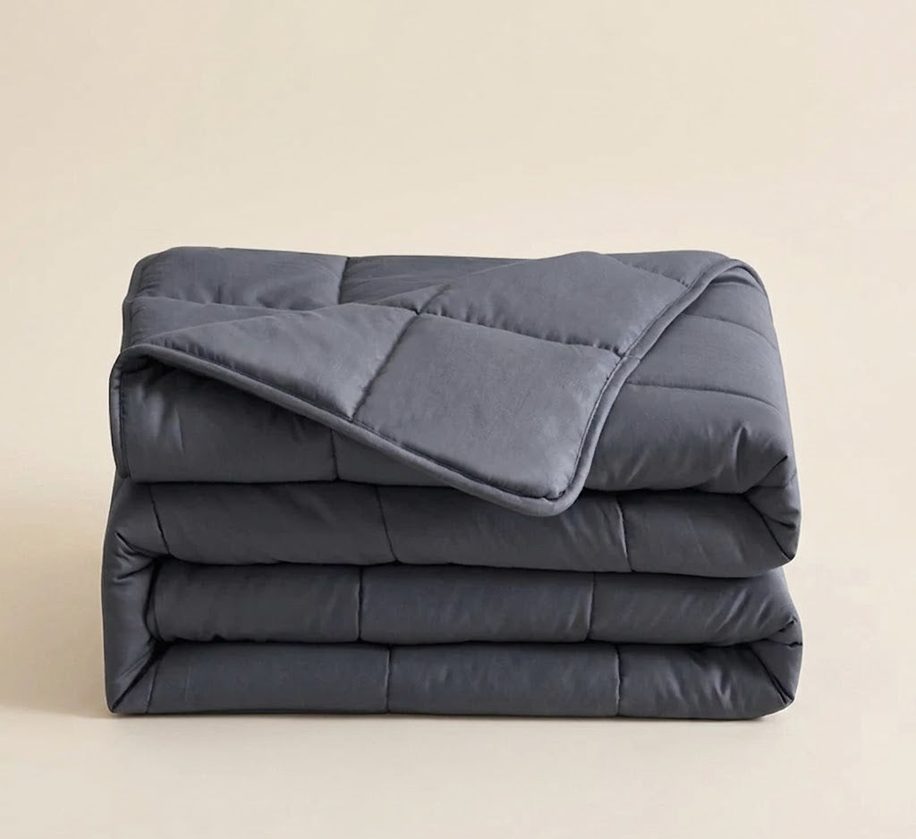 Folded gray comforter on a beige background